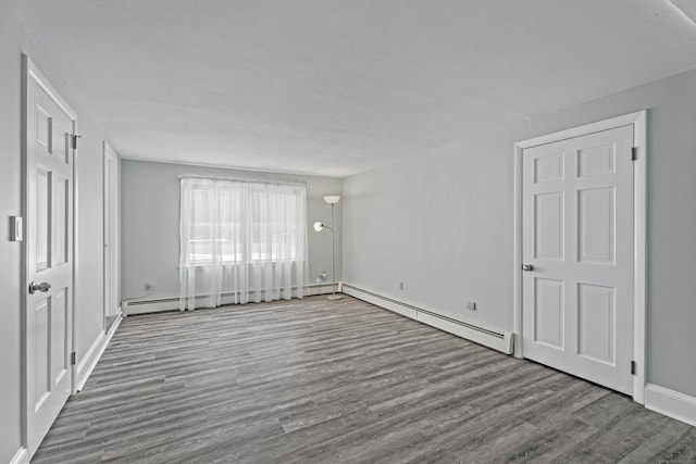 interior space with baseboard heating and wood finished floors