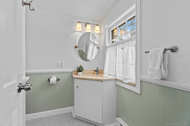 half bathroom featuring a wainscoted wall and vanity