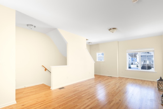 interior space with light wood-style floors, visible vents, and baseboards