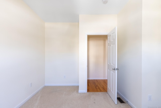 unfurnished bedroom with baseboards, visible vents, and light colored carpet