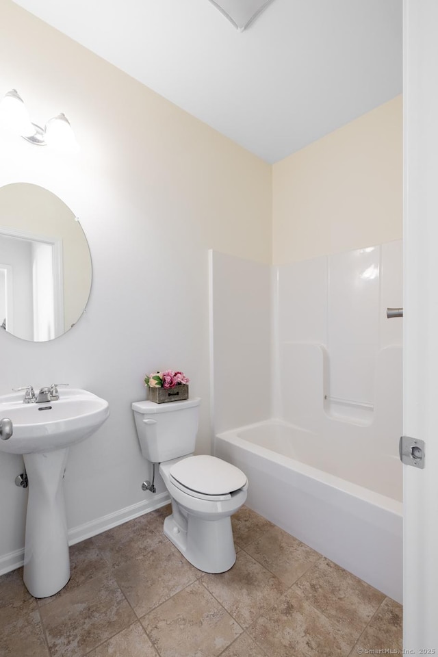 bathroom with shower / tub combination, toilet, and baseboards