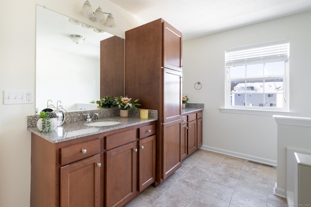 bathroom featuring visible vents, baseboards, tile patterned flooring, and vanity