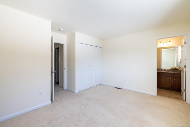 unfurnished bedroom with baseboards, visible vents, a closet, and light colored carpet