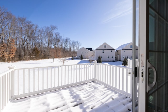 snow covered deck featuring a residential view