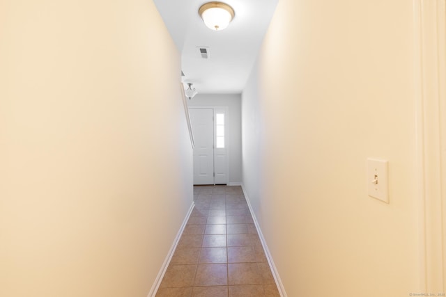 corridor featuring light tile patterned flooring, visible vents, and baseboards