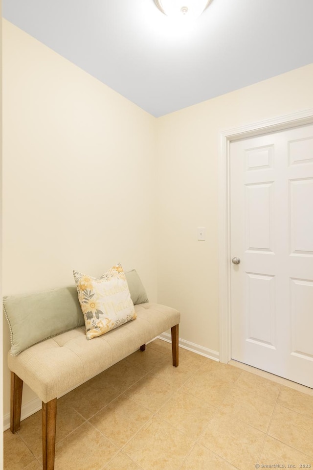 living area with baseboards and light tile patterned floors