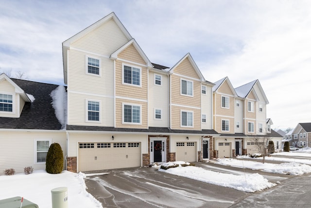 multi unit property featuring stone siding and an attached garage