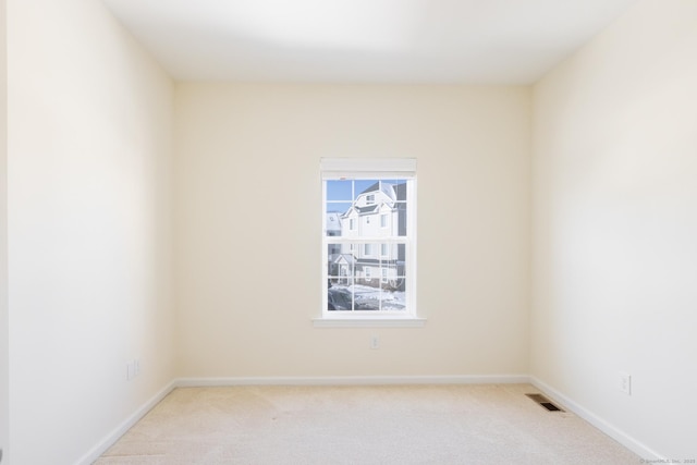 unfurnished room featuring light carpet, visible vents, and baseboards