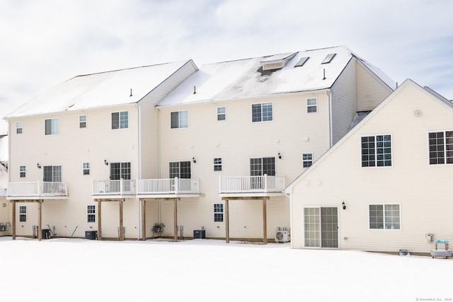 snow covered back of property with central air condition unit