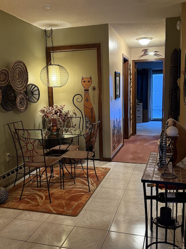 dining space with light tile patterned flooring and a textured ceiling