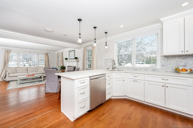 kitchen featuring kitchen peninsula, hanging light fixtures, sink, dishwasher, and white cabinets