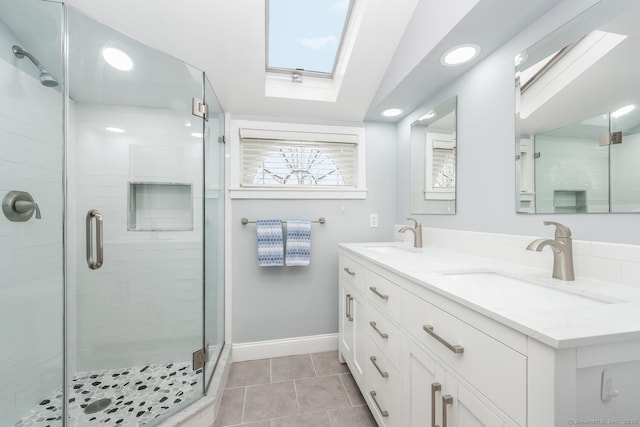 bathroom featuring tile patterned floors, a shower with shower door, a skylight, and vanity