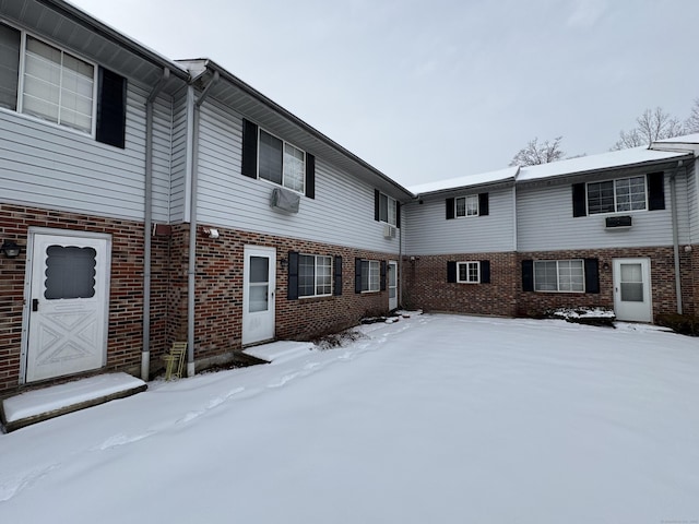 view of snow covered back of property