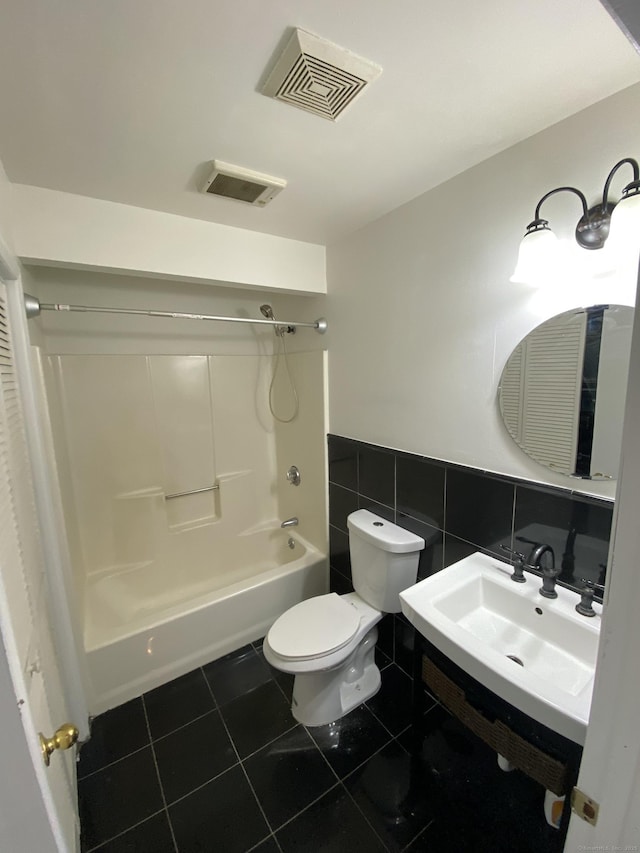 full bathroom featuring sink, tile walls, tile patterned flooring, shower / washtub combination, and toilet