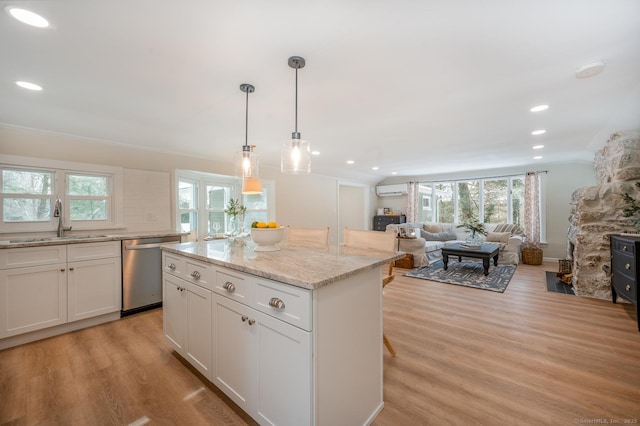 kitchen featuring light wood-style flooring, a sink, a wall unit AC, white cabinets, and dishwasher