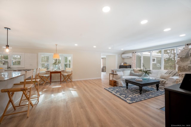 living room featuring light wood finished floors, plenty of natural light, recessed lighting, and a wall mounted AC