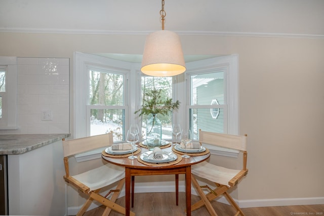 dining room with breakfast area, baseboards, and wood finished floors