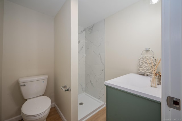 bathroom featuring a marble finish shower, toilet, and baseboards