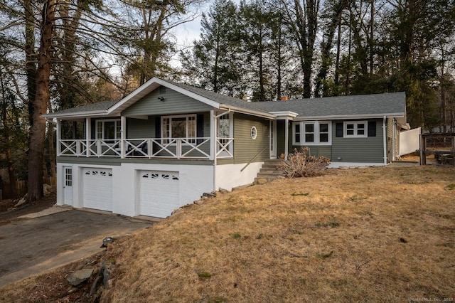 single story home featuring aphalt driveway, an attached garage, and a front lawn