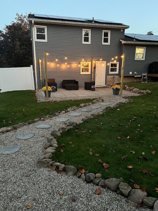 back of property with a lawn and a patio