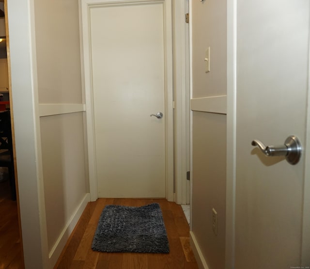 hallway with hardwood / wood-style flooring