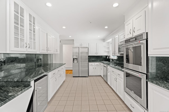 kitchen featuring sink, stainless steel appliances, wine cooler, white cabinets, and dark stone counters