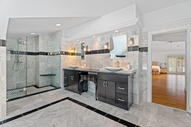 bathroom featuring vanity, an enclosed shower, and tile walls