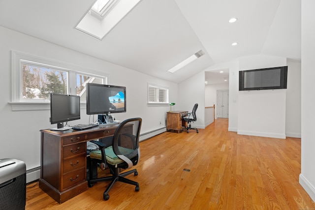 office area featuring a baseboard heating unit, light hardwood / wood-style floors, and vaulted ceiling with skylight