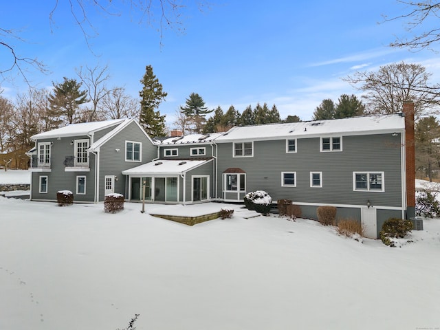 view of snow covered rear of property