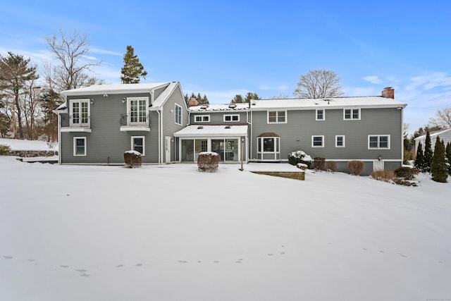 view of snow covered back of property