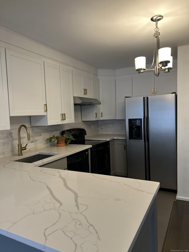 kitchen featuring decorative light fixtures, black appliances, light stone countertops, sink, and white cabinets