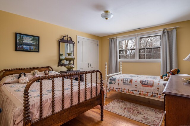 bedroom featuring a closet, visible vents, and wood finished floors