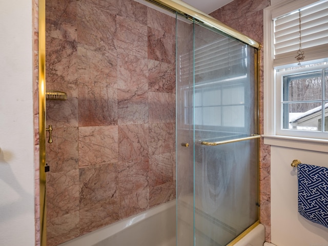 bathroom featuring combined bath / shower with glass door