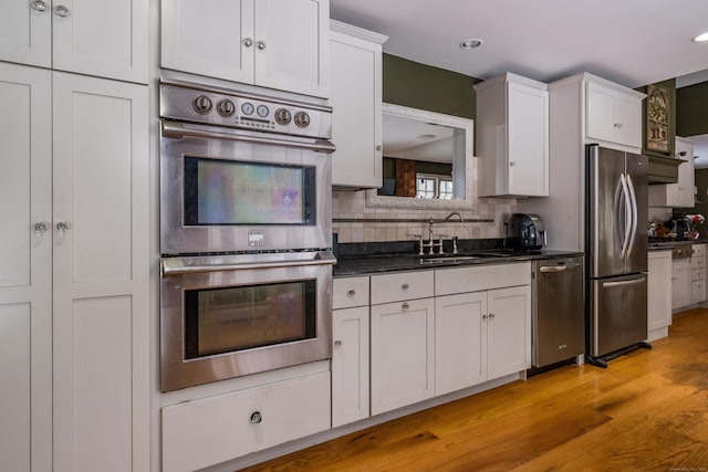 kitchen featuring white cabinetry, tasteful backsplash, appliances with stainless steel finishes, and a sink