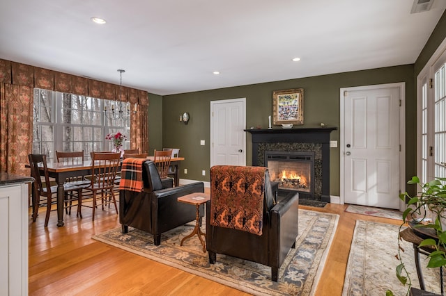 living area with light wood-style floors, a fireplace, baseboards, and recessed lighting