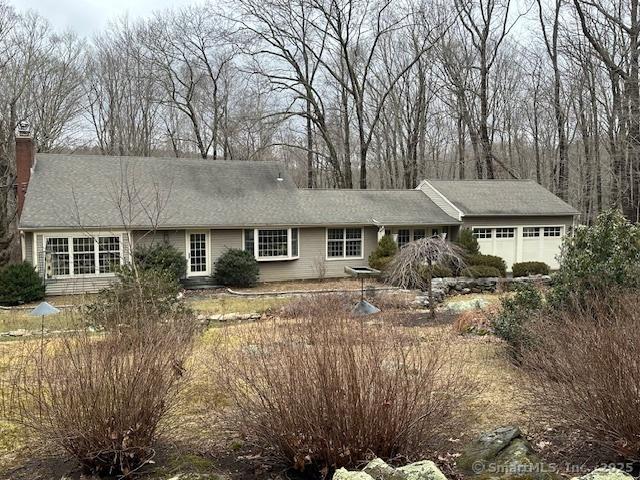 single story home with a chimney and an attached garage