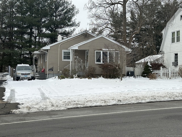 bungalow-style house with fence and central air condition unit