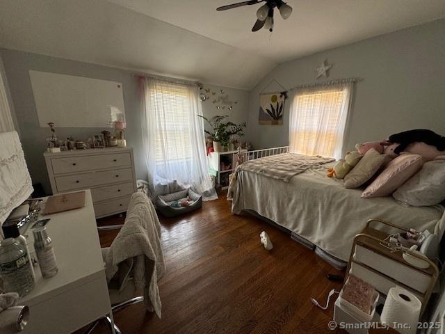 bedroom featuring ceiling fan, dark hardwood / wood-style flooring, and vaulted ceiling