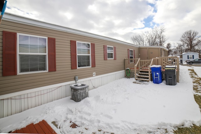 view of snowy exterior featuring a deck