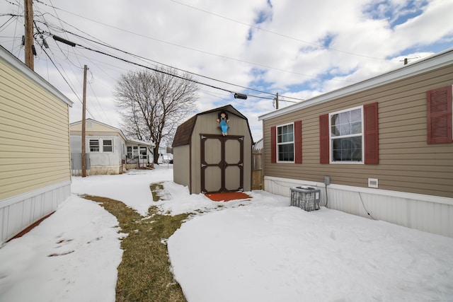 yard layered in snow with an outbuilding and a shed