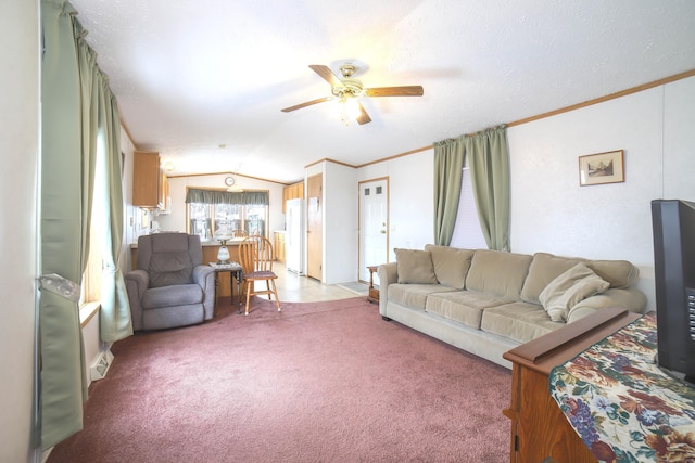 living room with ornamental molding, light colored carpet, vaulted ceiling, and ceiling fan