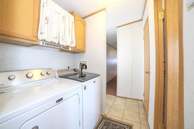 washroom with cabinet space, independent washer and dryer, a textured ceiling, and light tile patterned floors