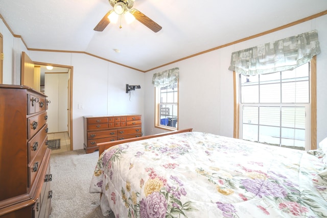 carpeted bedroom with lofted ceiling, crown molding, and ceiling fan