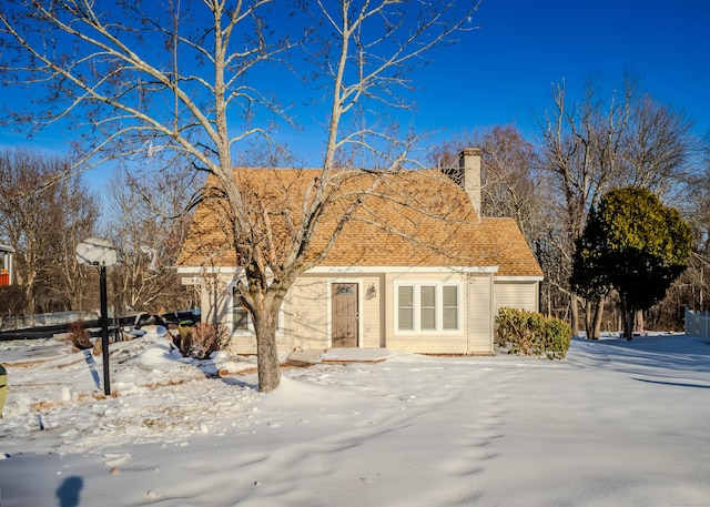 view of front of home with a shingled roof and a chimney