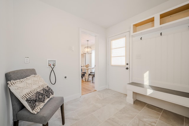 interior space featuring baseboards and a chandelier