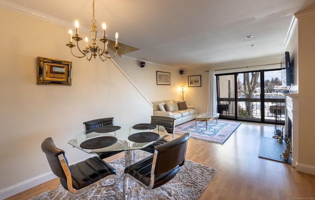 dining space with hardwood / wood-style flooring, ornamental molding, and an inviting chandelier