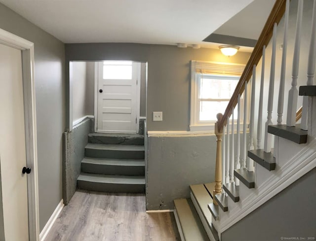 stairs with hardwood / wood-style floors and a healthy amount of sunlight