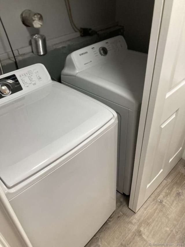 clothes washing area featuring light hardwood / wood-style floors