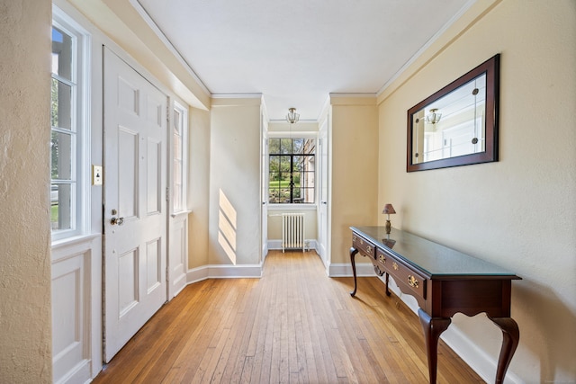 foyer with hardwood / wood-style flooring, radiator heating unit, and ornamental molding