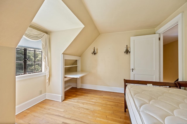 unfurnished bedroom with lofted ceiling and light hardwood / wood-style floors